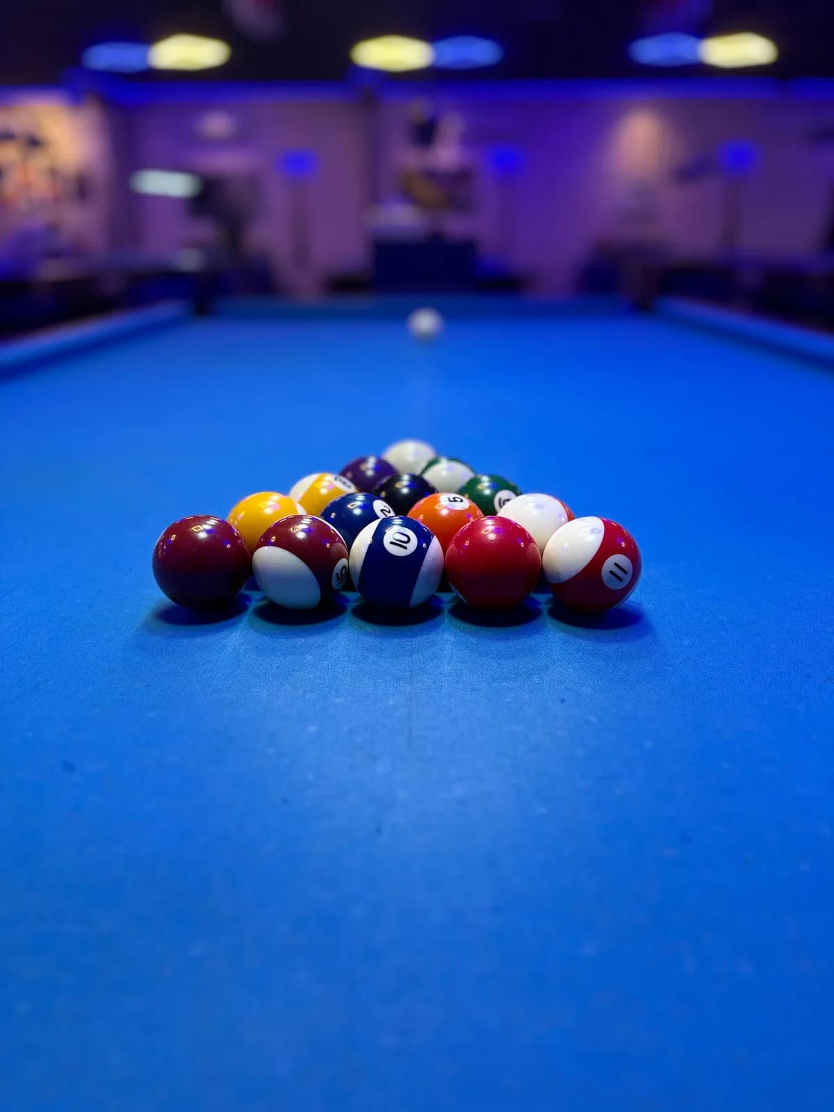 A racked set of pool balls on a blue table